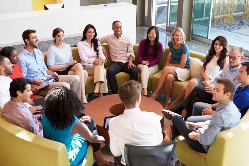 Multi-Cultural Office Staff Sitting Having Meeting Together